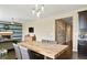 Light-filled dining area featuring a wooden table, pendant lighting, and adjacent living space with a fireplace at 26143 E Fremont Pl, Aurora, CO 80016