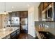 Modern kitchen featuring granite countertops, stainless steel appliances, and dark wood cabinets at 26143 E Fremont Pl, Aurora, CO 80016