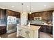 Stylish kitchen boasts dark cabinetry, stainless steel appliances, granite countertops, and a center island with seating at 26143 E Fremont Pl, Aurora, CO 80016