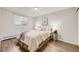 Cozy bedroom with wood flooring, soft lighting, and a comfortable queen-sized bed at 1349 Race St # 5, Denver, CO 80206