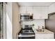 Updated kitchen featuring modern appliances, granite countertops, and stylish white cabinetry at 1349 Race St # 5, Denver, CO 80206