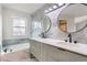 Modern bathroom with double sinks, updated mirrors, and a soaking tub with tile surround at 2358 Dogwood Cir, Louisville, CO 80027