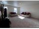 Sunlit living room with plush carpet, comfortable seating, and a large television at 2351 Monte Vista St, Fort Lupton, CO 80621