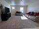 Bright living room featuring neutral carpet, cozy couches, and a modern entertainment center at 2351 Monte Vista St, Fort Lupton, CO 80621