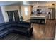 Open living area with a modern kitchen and a large, comfortable leather couch at 2351 Monte Vista St, Fort Lupton, CO 80621