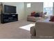 Inviting living room with new carpet, sofa, and a TV stand by a large window at 2351 Monte Vista St, Fort Lupton, CO 80621