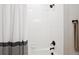 Clean bathroom featuring white tiles, black fixtures, and shower with patterned curtain at 16860 Askins Loop # 102, Parker, CO 80134