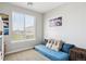 Bright bedroom featuring a large window, a cozy futon, and neutral decor at 16860 Askins Loop # 102, Parker, CO 80134