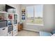 Well-lit bedroom with shelving unit, large window with green view, and a comfortable futon at 16860 Askins Loop # 102, Parker, CO 80134