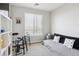 Neutral bedroom with large window, shelving unit, and a cozy black futon at 16860 Askins Loop # 102, Parker, CO 80134