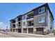 Attractive townhome complex with a gray exterior and individual garages at 16860 Askins Loop # 102, Parker, CO 80134