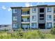 Multi-story townhome with balconies, gray exterior, and lush landscaping at 16860 Askins Loop # 102, Parker, CO 80134