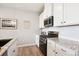 Modern kitchen boasts stainless steel appliances, granite countertops, and white cabinets at 16860 Askins Loop # 102, Parker, CO 80134