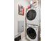 Modern stacked laundry machines, utility panel, and colorful cat art at 16860 Askins Loop # 102, Parker, CO 80134