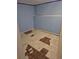 Unfinished basement with blue walls and deteriorating floor tiles at 16094 E Exposition Dr, Aurora, CO 80017