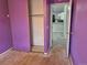 Bedroom with purple walls showing the closet and entry to the kitchen at 16094 E Exposition Dr, Aurora, CO 80017