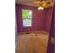 Bedroom with hardwood floors, purple walls, and a bright window overlooking the neighborhood at 16094 E Exposition Dr, Aurora, CO 80017