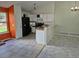Kitchen area featuring white cabinetry, black appliances and seamless transitions to the dining area at 16094 E Exposition Dr, Aurora, CO 80017