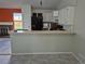 Cozy kitchen featuring white cabinetry, a black refrigerator, and a breakfast bar area at 16094 E Exposition Dr, Aurora, CO 80017