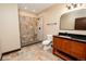Bathroom featuring a custom tiled shower, dark stained vanity, and tiled floors at 15175 Rainbow Dr, Sedalia, CO 80135