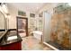 Bathroom featuring stone tile floors, a glass-enclosed shower, soaking tub, and door to the outdoor deck at 15175 Rainbow Dr, Sedalia, CO 80135