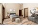 Bright bedroom with wood-look floors, a gray upholstered headboard, and industrial decor at 15175 Rainbow Dr, Sedalia, CO 80135
