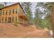 Exterior angle featuring a wood home with a deck that overlooks the natural wooded scenery at 15175 Rainbow Dr, Sedalia, CO 80135