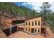 Hillside home featuring wood construction, large windows, and a garage with a driveway at 15175 Rainbow Dr, Sedalia, CO 80135