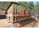 Exterior view of home with a large deck and many windows, nestled on a hillside at 15175 Rainbow Dr, Sedalia, CO 80135