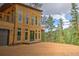 Stunning contemporary home exterior with wood siding, large windows, and a walkout balcony overlooking treed lot at 15175 Rainbow Dr, Sedalia, CO 80135
