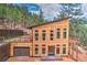 Striking contemporary home with light wood siding, large windows, garage, upper deck and a private treed lot at 15175 Rainbow Dr, Sedalia, CO 80135