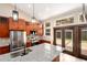 Bright kitchen features an island with a sink, stainless appliances, cabinets, wood floors, and glass doors to the outside at 15175 Rainbow Dr, Sedalia, CO 80135