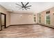 Spacious living room with hardwood floors, a ceiling fan, and lots of natural light from the many windows at 15175 Rainbow Dr, Sedalia, CO 80135