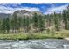 Picturesque scene of a flowing river with mountains and trees in the background at 15175 Rainbow Dr, Sedalia, CO 80135