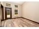 Naturally lit room featuring wood-look flooring, large windows, and a door to the backyard deck at 15175 Rainbow Dr, Sedalia, CO 80135