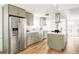 Stainless steel appliances and light green cabinets in kitchen at 3315 Ames St, Wheat Ridge, CO 80212