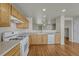 Bright kitchen with wooden cabinets, white appliances, and hardwood floors offers lots of room to move around at 1353 Mallard Ln, Brighton, CO 80601