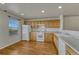 Well-lit kitchen featuring wood floors, light cabinets, and modern white appliances at 1353 Mallard Ln, Brighton, CO 80601