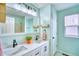 Bathroom featuring double sinks, a large mirror, and a tub with a shower, all in a refreshing color scheme at 5532 S Valdai Way, Aurora, CO 80015