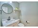Modern bathroom features stylish fixtures, vanity with marble countertop and round mirror at 5532 S Valdai Way, Aurora, CO 80015