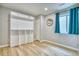 Bright bedroom with wood floors, a large window with blue curtains, and unique built-in shelving at 5532 S Valdai Way, Aurora, CO 80015