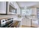 A close up of the stylish kitchen featuring a stainless steel microwave and modern sink at 5532 S Valdai Way, Aurora, CO 80015