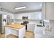 Bright kitchen with stainless steel appliances, white cabinets, an island, and quartz countertops at 5532 S Valdai Way, Aurora, CO 80015