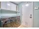 Cozy laundry room featuring gray washer and dryer, overhead cabinets, and convenient access door at 5532 S Valdai Way, Aurora, CO 80015