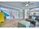 Open-concept living room with a ceiling fan, couch, and adjacent play area, with luxury vinyl floors at 5532 S Valdai Way, Aurora, CO 80015