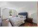 Bright bedroom featuring hardwood floors, a patterned comforter, and bedside lamps at 1612 S Logan St, Denver, CO 80210