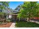 Charming home with a well-manicured lawn, mature tree, and inviting front porch at 1612 S Logan St, Denver, CO 80210