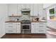 Modern kitchen boasts white cabinets, wood countertops, stainless steel appliances, and a bright window at 1612 S Logan St, Denver, CO 80210