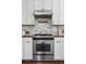 A close-up of a modern kitchen features white cabinets, wood countertops and stainless steel appliances at 1612 S Logan St, Denver, CO 80210