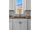 A close up of a modern kitchen sink with wood countertop and marble backsplash in front of a window at 1612 S Logan St, Denver, CO 80210